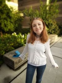 Portrait of smiling teenage girl standing outdoors