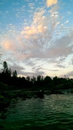 Scenic view of lake against cloudy sky