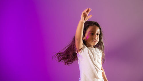 Portrait of a girl standing against pink background