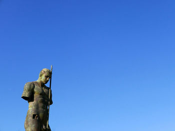 Low angle view of statue against clear blue sky