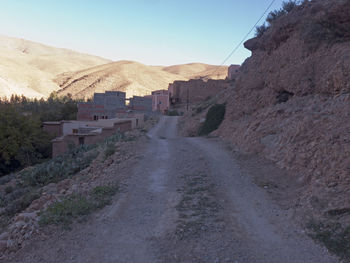 Road amidst buildings against sky