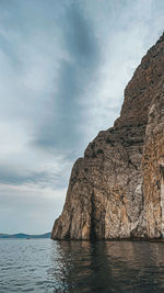 Rock formations by sea against sky