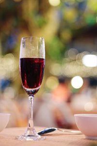 Close-up of red wine in champagne flute on table