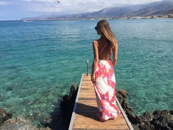 Rear view of woman standing on beach