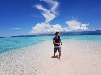 Full length of man standing on beach against sky