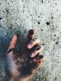 Cropped image of dirty hand against wall