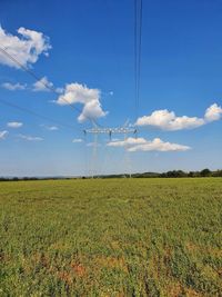 Electricity pylon on field against sky