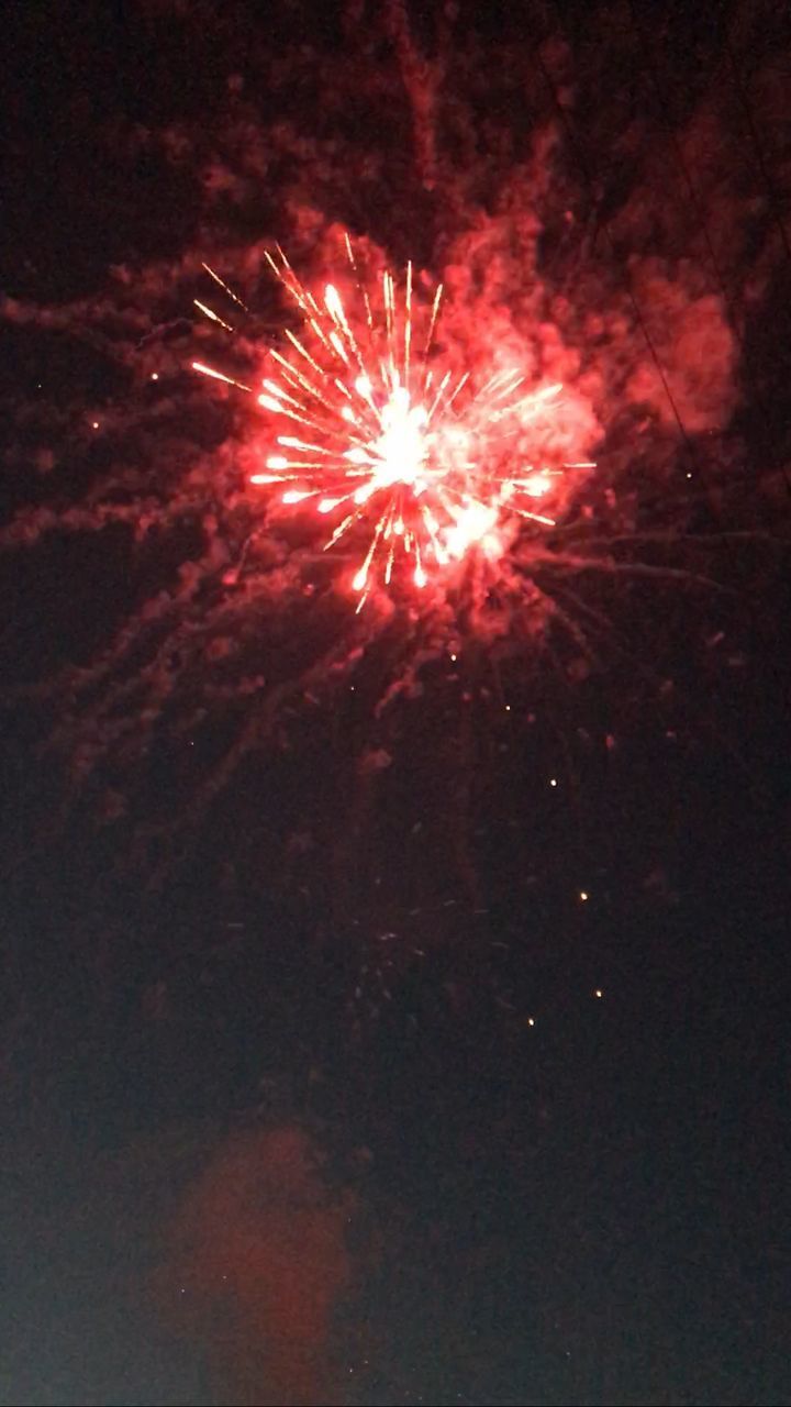 LOW ANGLE VIEW OF FIREWORKS EXPLODING AT NIGHT