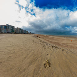 Empty beach with a footprint in sint-idesbald at koksijde in autumn with a cloudy sky 