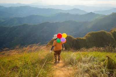 Rear view of woman standing on mountain