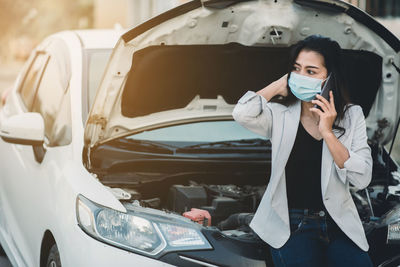 Young woman using smart phone in car