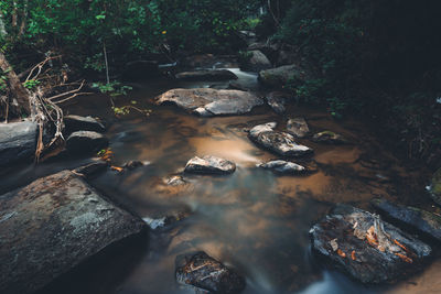 High angle view of stream flowing through rocks