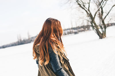 Rear view of woman on snow field during winter