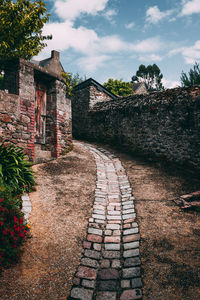 Footpath amidst buildings against sky