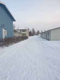 Snow covered houses and buildings against sky