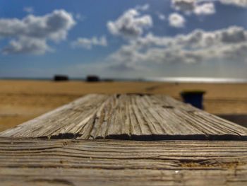 Surface level of wooden plank against sky