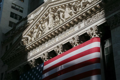 Low angle view of flag against building in city