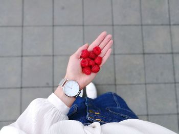 Low section of woman holding raspberries