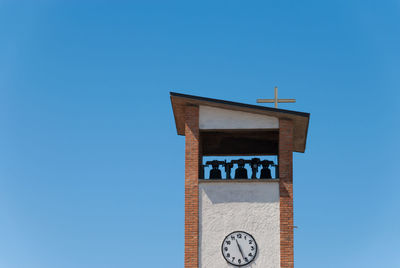 Low angle view of clock tower against clear blue sky