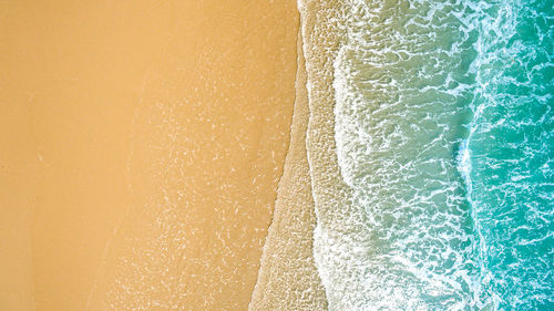 Close-up of yellow umbrella on beach