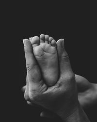 Close-up of human hand against black background