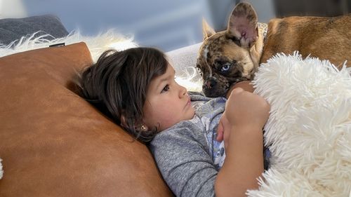 Midsection of woman with dog on bed at home