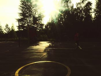 View of basketball hoop on road against sky