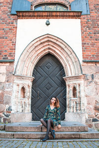 Portrait of woman sitting outside building