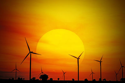 Low angle view of wind turbines during sunset