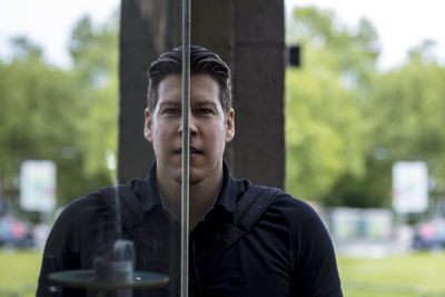 Close-up portrait of mature man standing against wall