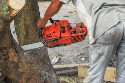 Man working on tree trunk at construction site