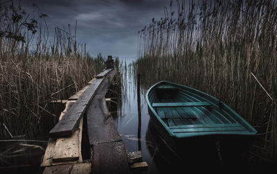 Boats on field against sky at dusk