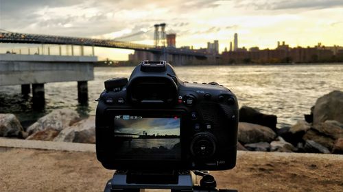 Close-up of camera against cityscape