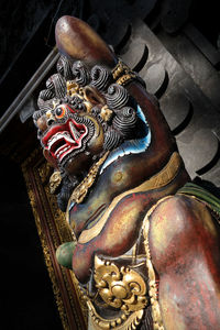 Low angle view of buddha statue against building