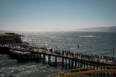 Bridge over sea against clear sky