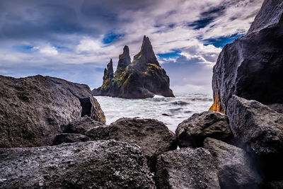 Rocks on beach against sky