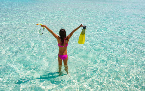 Woman wearing bikini standing in sea