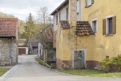 Residential building by road against sky