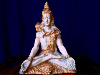 Close-up of buddha statue against blue background