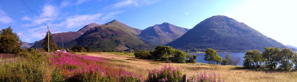 Panoramic view of field and mountains against sky