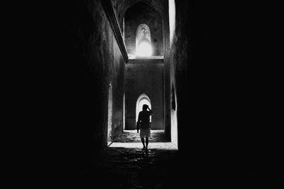 Rear view of woman walking in tunnel