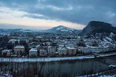 Aerial view of townscape by lake against sky