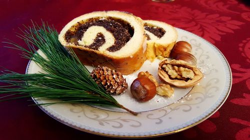 High angle close-up of sweet food with pine cones and leaves in plate on table