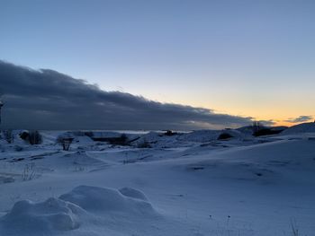 Scenic view of snow covered landscape against sky during sunset