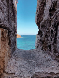 Rock formations on beach against clear sky