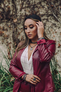 Beautiful young woman standing against plants
