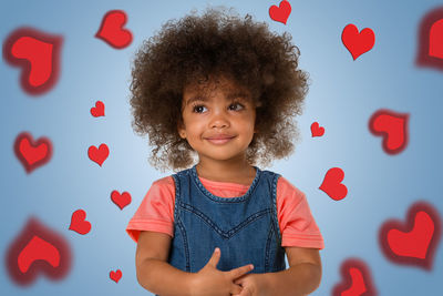 Portrait of smiling boy standing against red wall