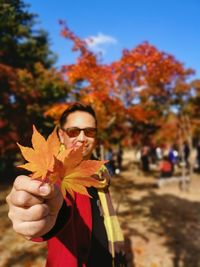 Portrait of woman holding maple leaf