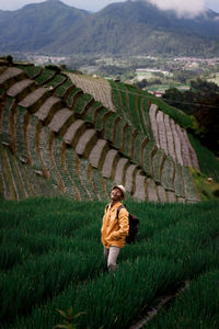 Rear view of woman standing on field