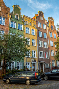 Cars on street by buildings against sky